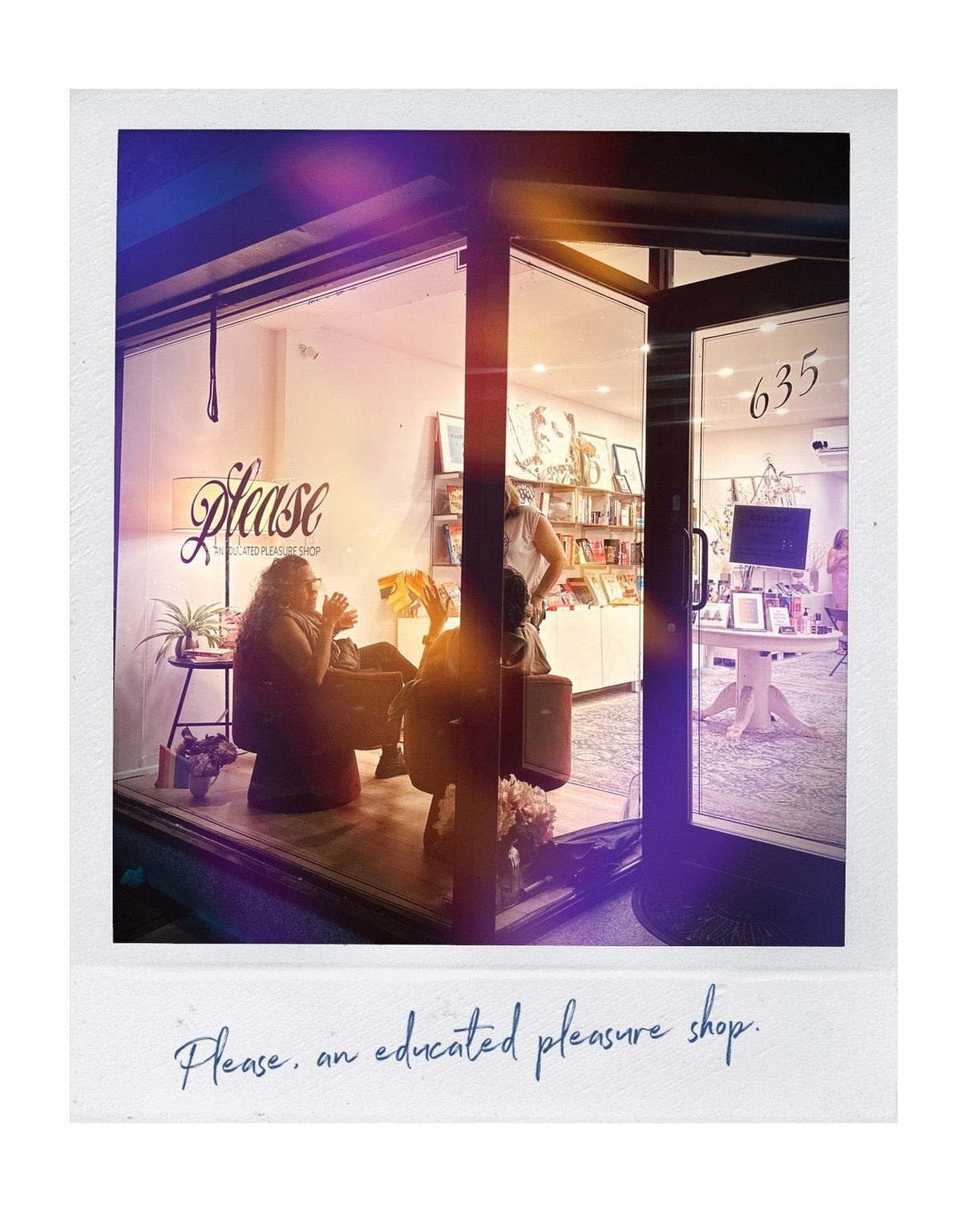 A Polaroid-style photo print of a boutique sex shop storefront at night, with warm interior lighting visible through large glass windows and doors. The print includes a white border with the text 'Please, an educated pleasure shop. Nominated brooklyn's best sex shop and adult toys store